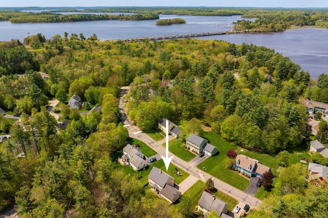 aerial view of property's location with a large body of water and a heavily wooded area