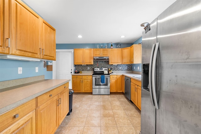 kitchen featuring stainless steel appliances, under cabinet range hood, light countertops, decorative backsplash, and recessed lighting