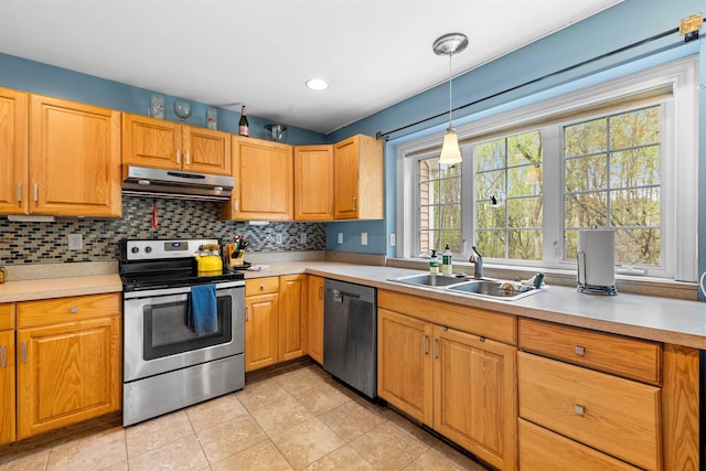 kitchen with stainless steel appliances, under cabinet range hood, a sink, light tile patterned floors, and light countertops