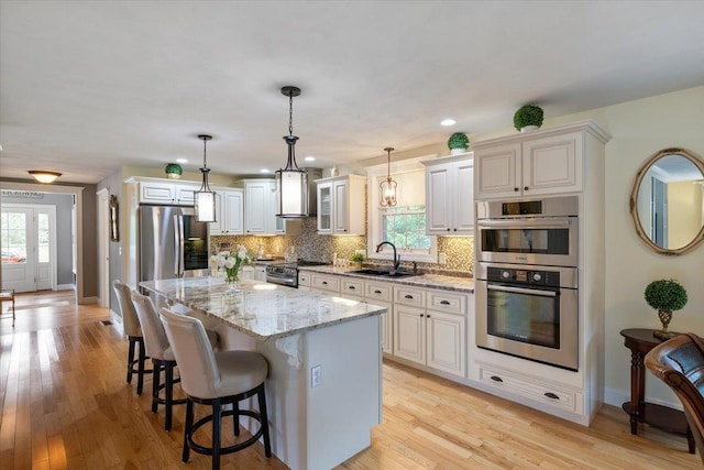 34 Coles Pond Rd, Somersworth, NH 03878 - kitchen with a sink, appliances with stainless steel finishes, light stone countertops, wall chimney range hood, and backsplash
