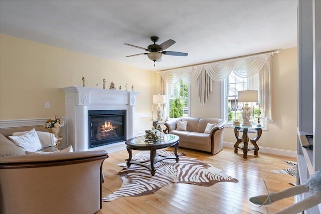 34 Coles Pond Rd, Somersworth, NH 03878 - living area with ceiling fan, a glass covered fireplace, light wood finished floors, and baseboards