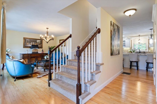 34 Coles Pond Rd, Somersworth, NH 03878 - staircase with wood-type flooring, a chandelier, and baseboards