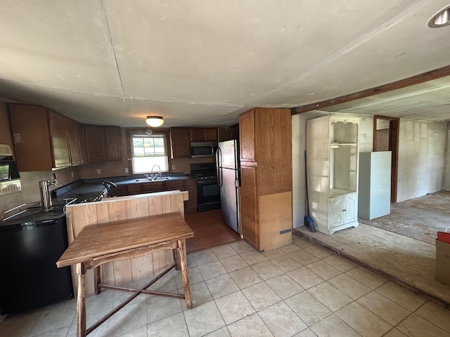 311 Clinton St, Concord, NH 03301 - kitchen with stainless steel appliances, light tile patterned floors, and a sink