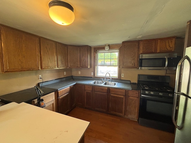 311 Clinton St, Concord, NH 03301 - kitchen with appliances with stainless steel finishes, a sink, dark wood-style flooring, and brown cabinetry