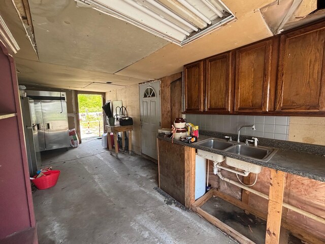 311 Clinton St, Concord, NH 03301 - kitchen featuring a sink, unfinished concrete floors, dark countertops, and backsplash