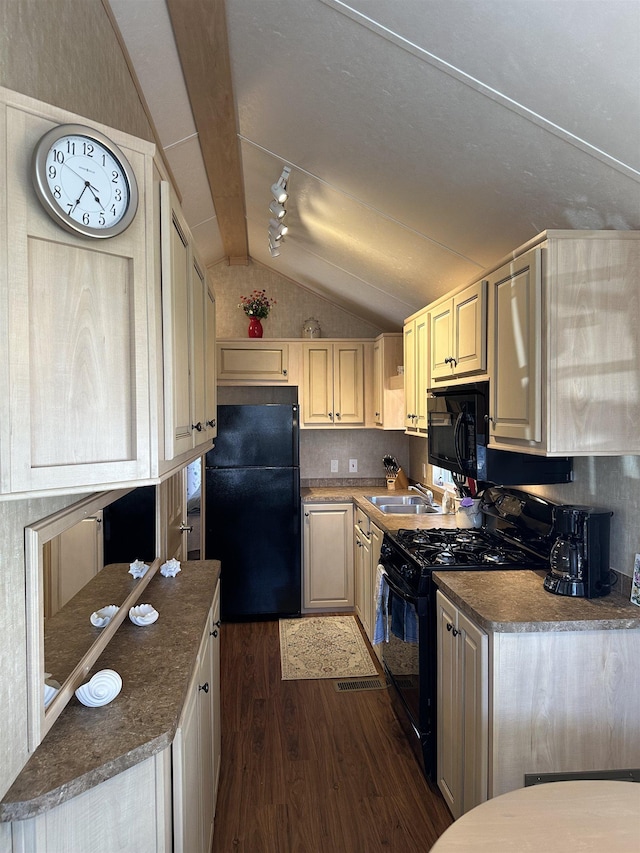kitchen with black appliances, dark wood-style floors, vaulted ceiling, a sink, and dark countertops