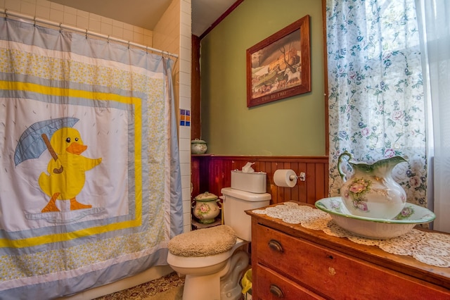 full bath featuring wainscoting, curtained shower, toilet, and vanity