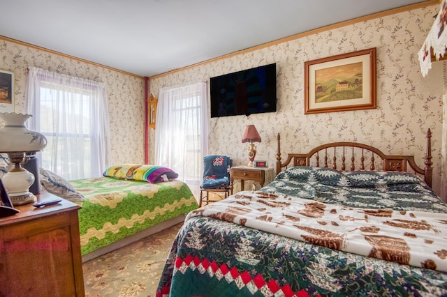 bedroom with wallpapered walls and crown molding