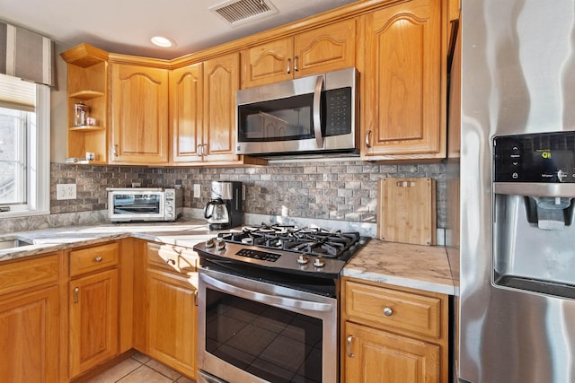 605 Ocean Blvd Unit 1, Hampton, NH 03842 - kitchen with appliances with stainless steel finishes, backsplash, light stone counters, light tile patterned floors, and open shelves