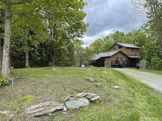 view of yard featuring a deck and driveway