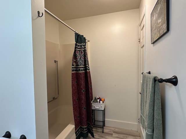 bathroom featuring a shower with curtain, wood finished floors, and baseboards