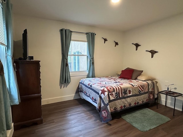 bedroom featuring wood finished floors and baseboards