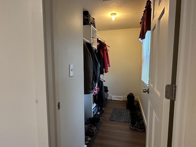 spacious closet with dark wood-style floors