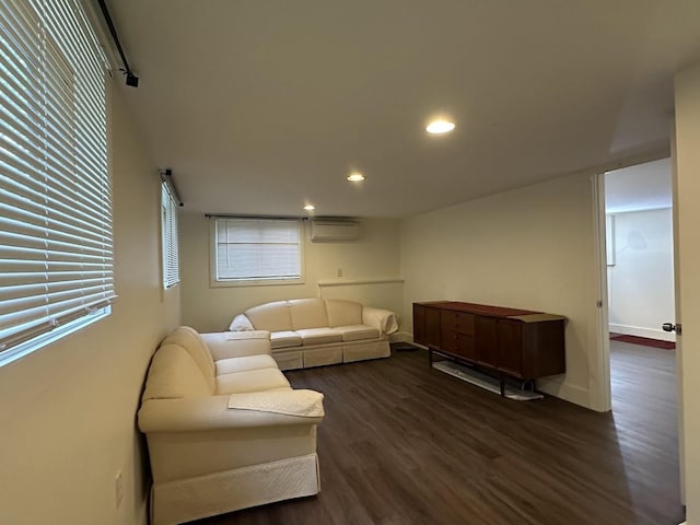 living area featuring a wall mounted air conditioner, dark wood finished floors, recessed lighting, and baseboards