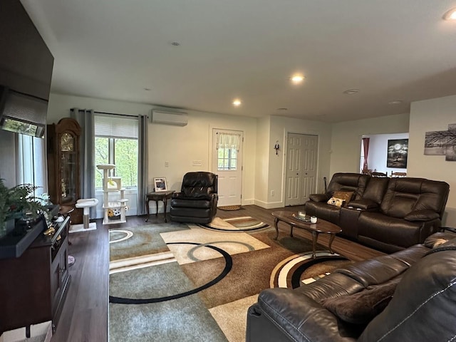 living area with wood finished floors, an AC wall unit, plenty of natural light, and recessed lighting