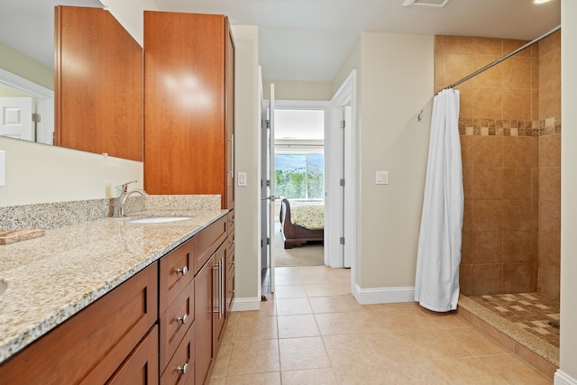 7 Timberbrook N, Dorset, VT 05251 - ensuite bathroom with tiled shower, baseboards, vanity, and tile patterned flooring