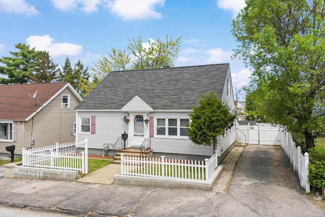 552 Dix St, Manchester, NH 03103 - cape cod home featuring a shingled roof, a fenced front yard, and asphalt driveway