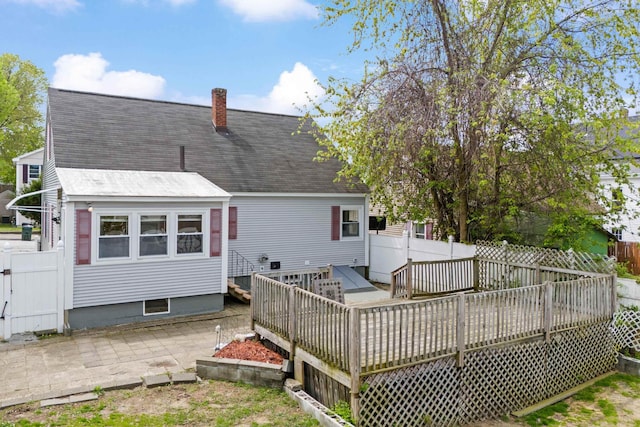 552 Dix St, Manchester, NH 03103 - back of house featuring a wooden deck, a chimney, fence, and a shingled roof