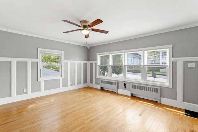 552 Dix St, Manchester, NH 03103 - unfurnished room featuring radiator heating unit, light wood-type flooring, ceiling fan, crown molding, and a decorative wall