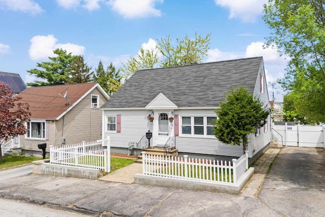 552 Dix St, Manchester, NH 03103 - cape cod home featuring a fenced front yard, roof with shingles, and a gate