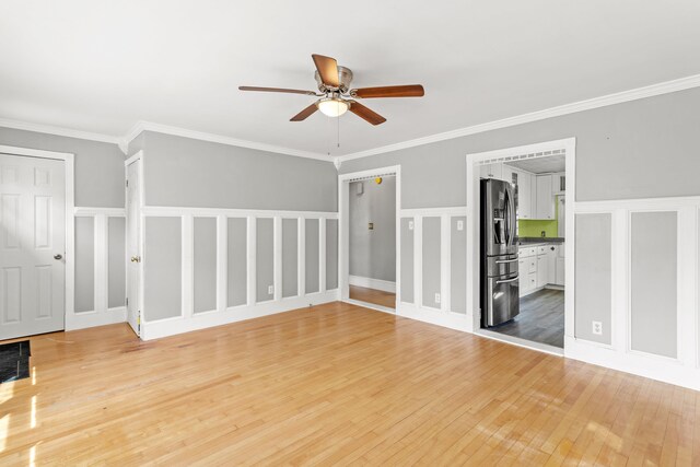 552 Dix St, Manchester, NH 03103 - unfurnished room with a ceiling fan, light wood-style flooring, a decorative wall, a wainscoted wall, and crown molding