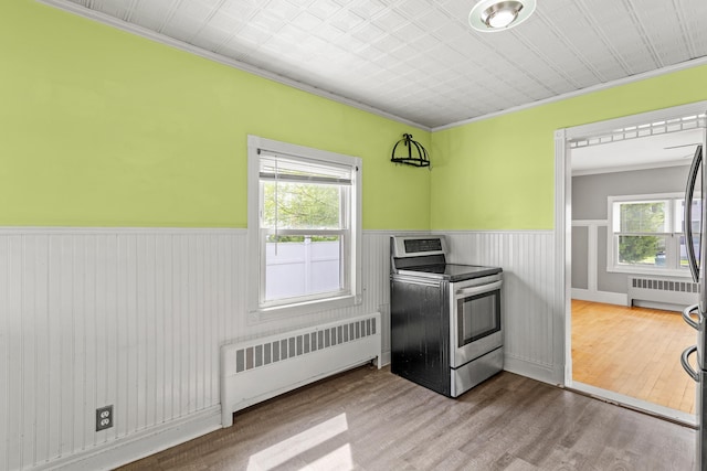 552 Dix St, Manchester, NH 03103 - kitchen with radiator, electric range, a wainscoted wall, crown molding, and wood finished floors