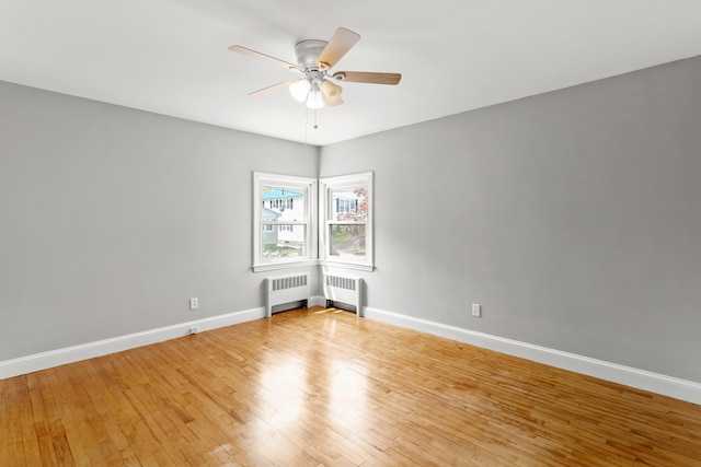 552 Dix St, Manchester, NH 03103 - unfurnished room featuring radiator, light wood finished floors, a ceiling fan, and baseboards