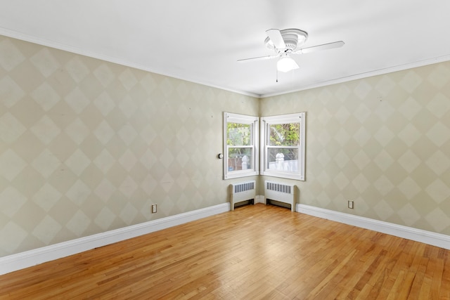 552 Dix St, Manchester, NH 03103 - spare room featuring light wood-type flooring, radiator heating unit, ceiling fan, crown molding, and baseboards