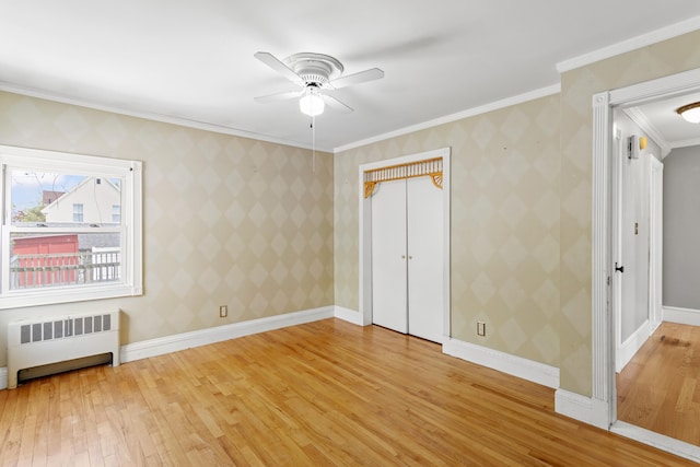 552 Dix St, Manchester, NH 03103 - unfurnished bedroom featuring radiator heating unit, light wood-style floors, ornamental molding, a ceiling fan, and baseboards