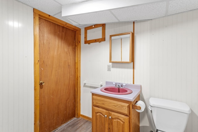 552 Dix St, Manchester, NH 03103 - half bathroom with a drop ceiling, toilet, vanity, and wood finished floors