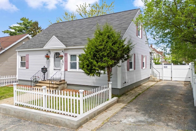 552 Dix St, Manchester, NH 03103 - new england style home with a fenced front yard, roof with shingles, a gate, and asphalt driveway
