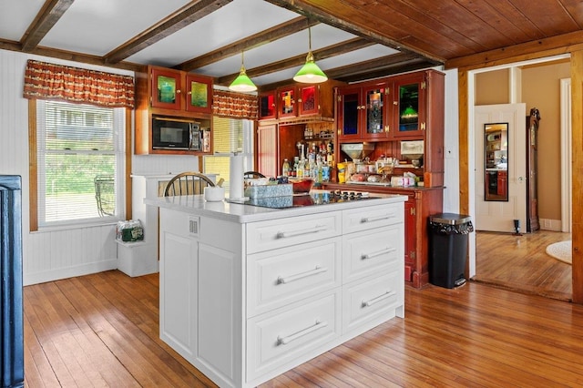 kitchen featuring light wood-type flooring, black appliances, glass insert cabinets, beamed ceiling, and white cabinets