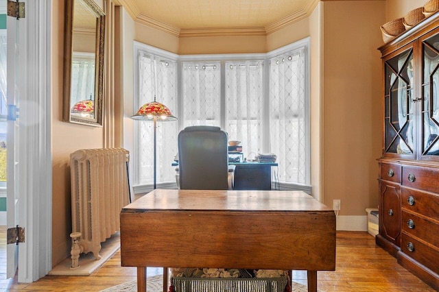 office area with radiator heating unit, wood-type flooring, ornamental molding, and plenty of natural light