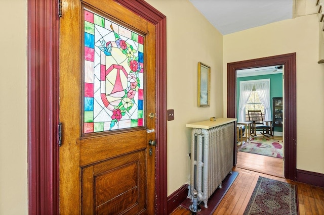 entryway with wood-type flooring and baseboards