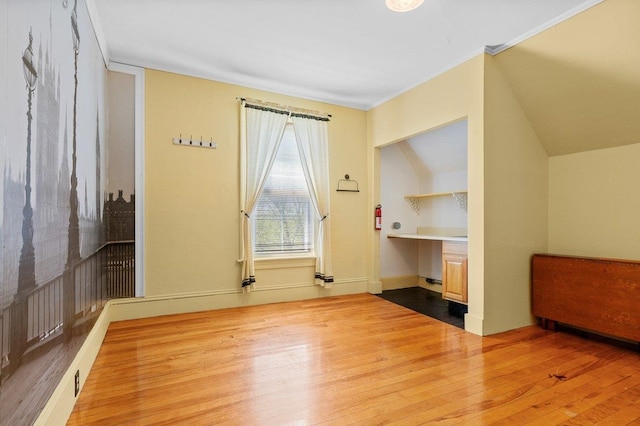 unfurnished bedroom with wood-type flooring, ornamental molding, and baseboards
