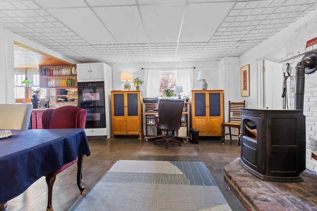 home office with a wood stove and a drop ceiling