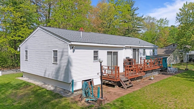 rear view of house with a deck, a yard, a patio, and roof with shingles