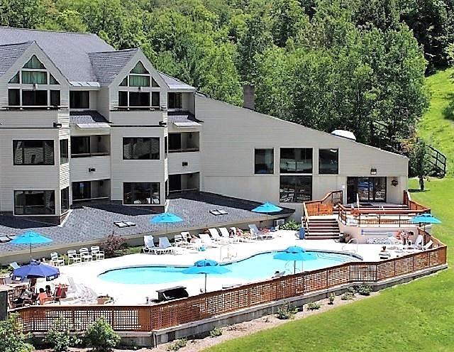 rear view of house featuring a community pool, a patio area, and a lawn