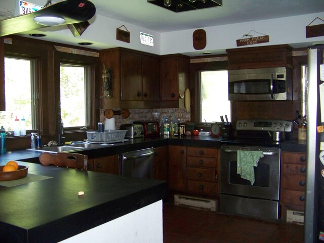 111 Forest Ln, Rochester, VT 05767 - kitchen with stainless steel appliances, dark countertops, a sink, and tasteful backsplash