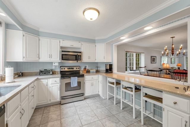 40-21 Harbor Way Unit 21, Wolfeboro, NH 03894 - kitchen featuring appliances with stainless steel finishes, ornamental molding, white cabinetry, a chandelier, and a kitchen bar