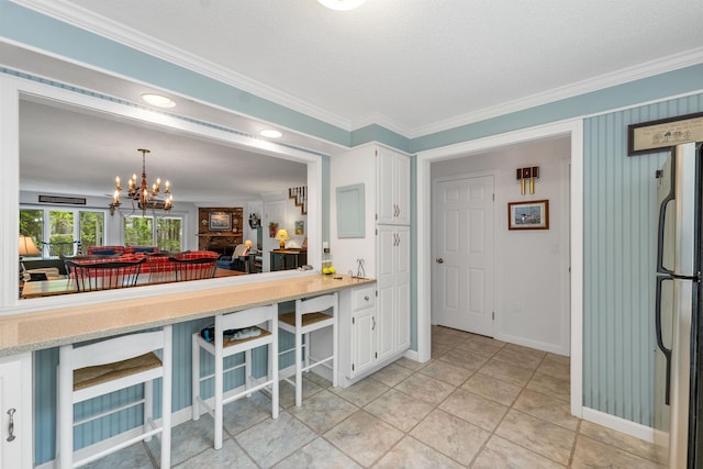40-21 Harbor Way Unit 21, Wolfeboro, NH 03894 - kitchen with freestanding refrigerator, white cabinetry, light countertops, a chandelier, and crown molding