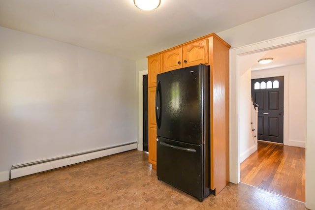kitchen with a baseboard radiator, freestanding refrigerator, and baseboards