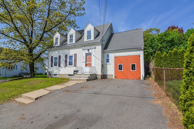 new england style home with driveway and an attached garage