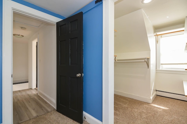 hallway with baseboards, carpet, and baseboard heating
