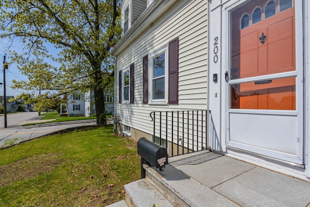 view of exterior entry with a yard