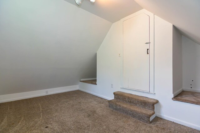 additional living space with vaulted ceiling, carpet flooring, and baseboards
