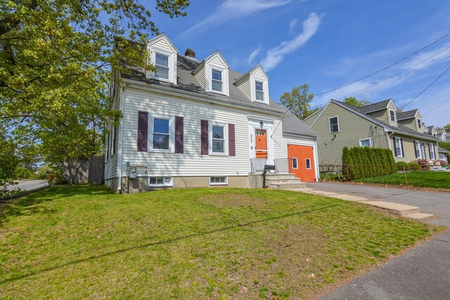 cape cod-style house with driveway, a chimney, an attached garage, and a residential view
