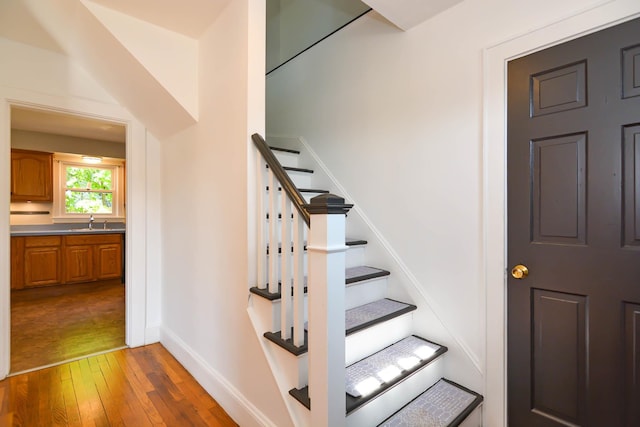stairs featuring hardwood / wood-style floors and baseboards