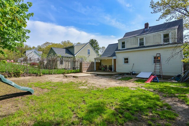 back of property featuring a chimney, a playground, and a patio area