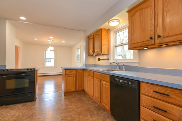 kitchen with black appliances, a sink, a baseboard radiator, a peninsula, and light countertops